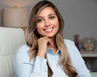 woman sitting in her office at desk with hand casually holding chin