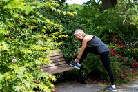 woman tying her sneaker leaning on a bench in a providence park